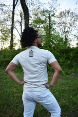 Male model wearing a cream colored t-shirt with a small, No Egrets birdcage logo in black on the back between the shoulders.