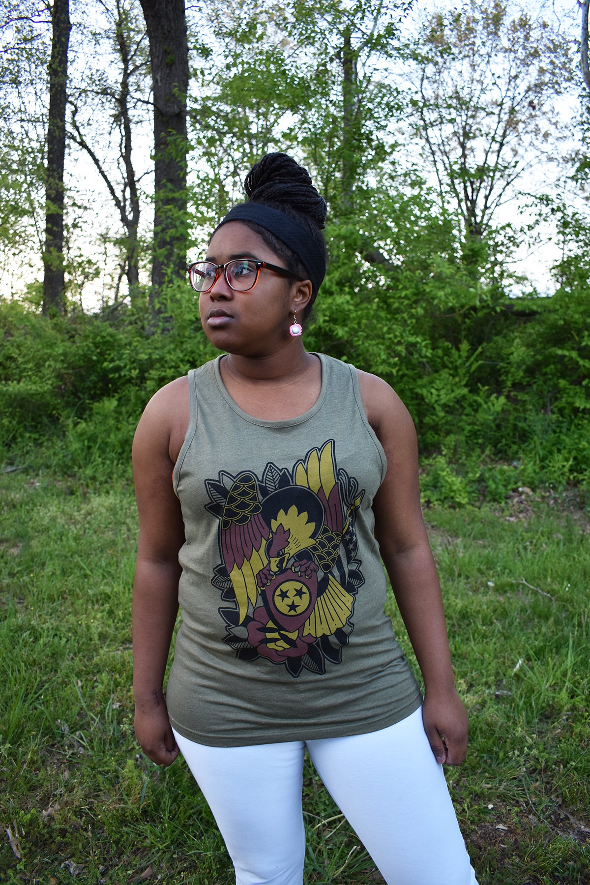 Female model wearing a green tank top with Brice Hamm's Tri-Star Eagle design in black, gold, and red on the front.