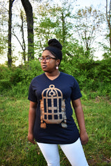 Female model wearing v-neck navy t-shirt with Fred Palmer's Robot Birdcage design in gold on the front.