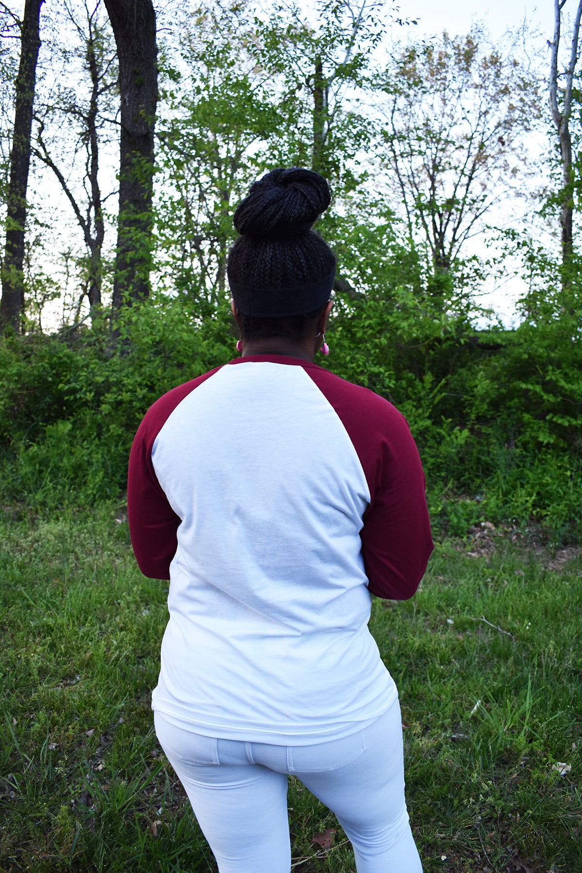 Female model wearing a baseball tee with a white body and red sleeves.