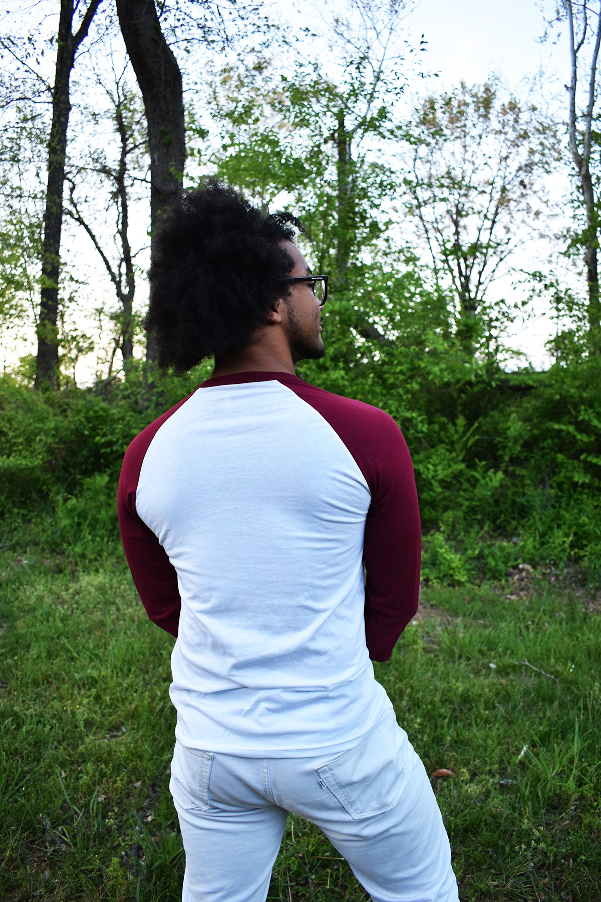 Male model wearing a baseball tee with a white body and red sleeves.