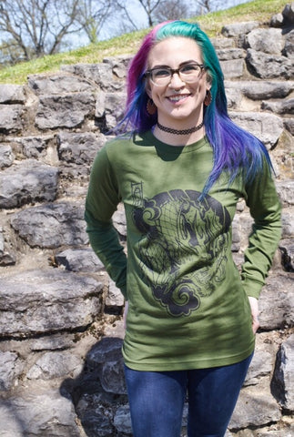 Female model wearing a green, long-sleeved shirt with Cameron McKnight's Dragon design in black on the front.
