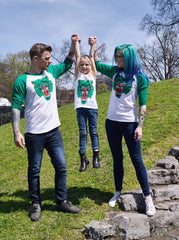 Three models (adult male, adult female, and female child) all wearing a baseball tee with a white body and green sleeves with Ben Drawdy's Battle Cat design in green, red, and black on the front.